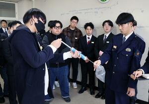 飲酒検知器を使って実際の警察業務を体験する学生ら＝新潟市西区小新西２