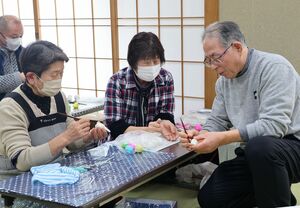 縁起物の「いんころ」を作る住民ら=柏崎市米山町