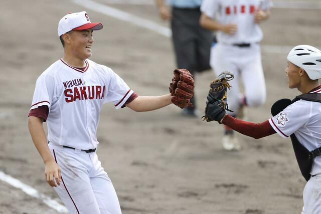 村上桜ケ丘－新潟西　無安打無得点試合を達成し、捕手の佐藤壮一郎（右）のミットにグラブを差し出して喜びを分かち合う渡辺勇陽＝新発田市五十公野