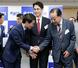 　中道改革連合の新代表に選出され、野田前共同代表（右）と握手する小川淳也氏。中央は階猛氏＝１３日午後、東京・永田町の党本部