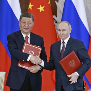 共同声明に署名し握手する中国の習近平国家主席(左)とロシアのプーチン大統領=5月、モスクワ(新華社=共同)