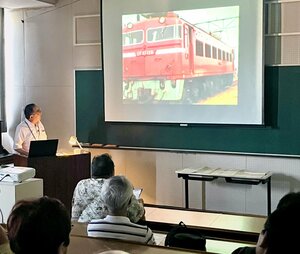 旧国鉄時代に撮影された列車の映像を解説する磯部正昭さん(左)=新潟市秋葉区