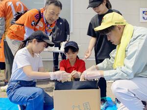 参加親子らと堆肥を作るアルビレックス新潟の谷口海斗選手(右)=4月29日、聖籠町
