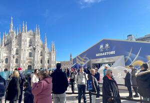 観光名所の「ミラノ大聖堂(ドゥオーモ)」と、行列ができる五輪公式ショップ=イタリア・ミラノ