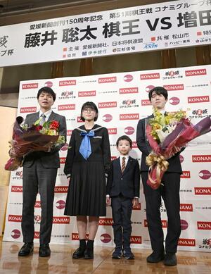 将棋の第５１期棋王戦コナミグループ杯５番勝負第１局の前夜祭で、子どもたちと記念写真に納まる藤井聡太棋王（右端）と増田康宏八段＝７日午後、松山市