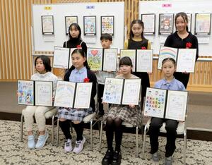 賞状を手に笑顔を見せる人権イラスト展の入賞者=新潟市中央区一番堀通町1