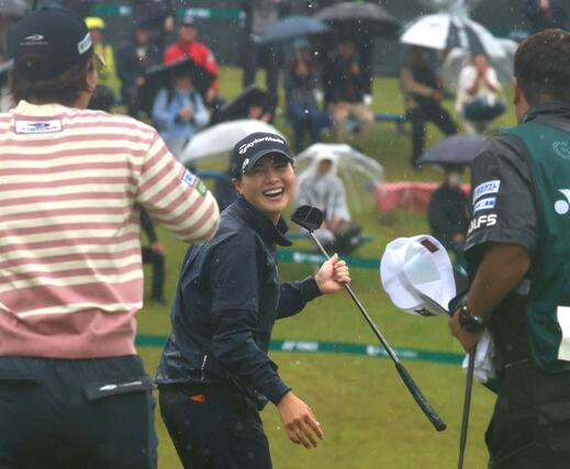 最終の18番ホールで優勝が決まり、照れながら笑顔で喜びを表す新垣比菜=長岡市ヨネックスカントリークラブ