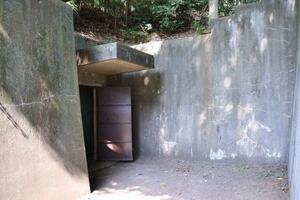 神奈川県の米陸軍キャンプ座間に現存している防空壕の出入り口(左奥)=7月
