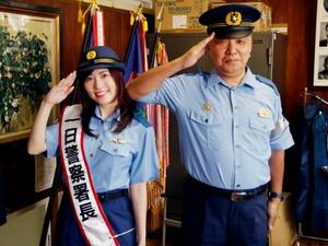 愛知県警西尾署の一日署長を委嘱され、中島信彦署長(右)と敬礼するタレントの松井珠理奈さん=29日午後、西尾市の県立鶴城丘高