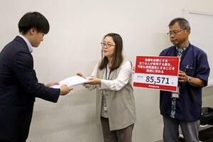 厚労省の担当者に署名を提出する大藤朋子さん(中央)=18日午前、参院議員会館