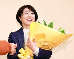 　前橋市長選で再選を決め、花束を手にする小川晶氏＝１２日夜、前橋市