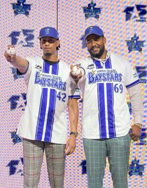 入団記者会見し、ポーズをとるDeNAのオスバルド・ビド投手(左)と、ヘラル・エンカーナシオン外野手=16日、横浜市内