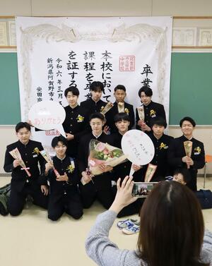 大きな卒業証書の前で写真に収まる安田中の卒業生=3月5日、阿賀野市保田