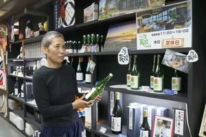 ツアーで訪れる尾畑酒造で日本酒を手に取る中村悦子さん=佐渡市真野新町