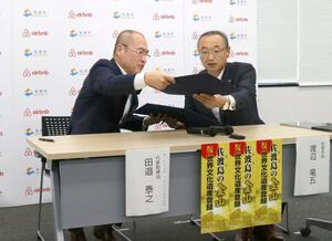 連携協定締結式に臨む渡辺竜五・佐渡市長(右)と「Airbnb Japan」の田邉泰之代表=新潟県佐渡市役所