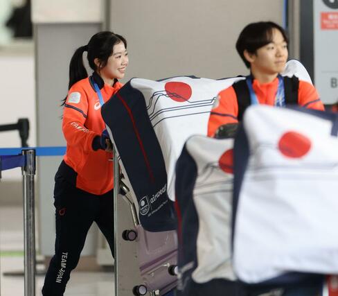 帰国したフィギュアスケート女子の中井亜美（左）＝２４日、成田空港