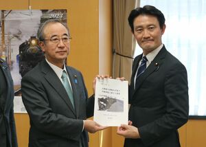 井林辰憲内閣府副大臣（右）に国土強靱化に関する要望書を手渡す花角英世知事＝３月１８日、内閣府
