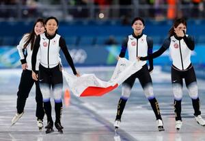 　女子団体追い抜きで銅メダルを獲得し、日の丸を掲げ場内を回る（左から）堀川桃香、高木美帆、野明花菜、佐藤綾乃＝ミラノ（共同）