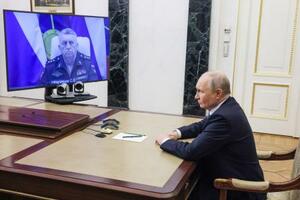 　ロシア軍戦略ミサイル部隊司令官から報告を受けるプーチン大統領＝１２日、モスクワ（タス＝共同）