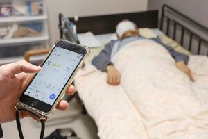 ベッドマットレス下に設置したAI搭載センサーから送られたデータを表示した職員のスマートフォン。入居者の状況がすぐに把握できる=新潟市東区の「大山愛宕の園」
