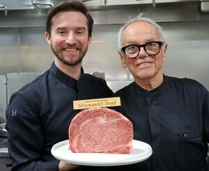 宮崎牛を持つシェフのウルフギャング・パックさん(右)と息子のバイロンさん=12日、米ロサンゼルス(共同)