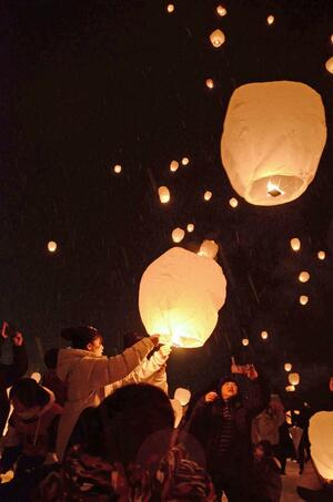 スカイランタンを打ち上げる来場者=津南町秋成