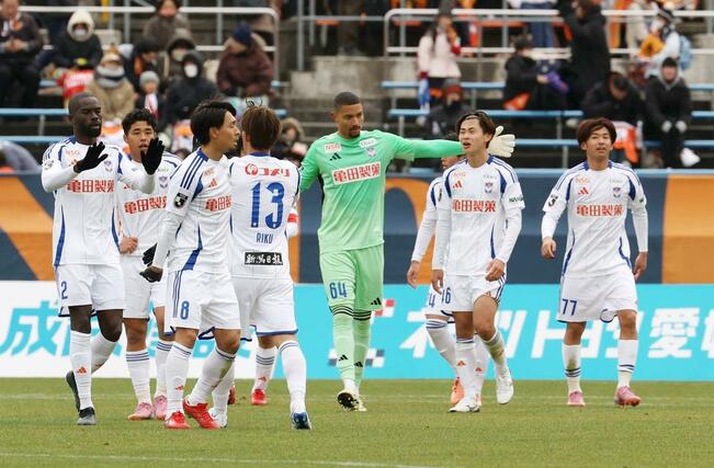 初勝利を決め、喜ぶ新潟の選手＝松山市