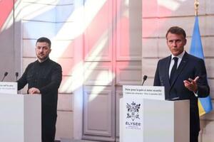 4日、フランス・パリで開かれた有志国連合の会合後、ウクライナのゼレンスキー大統領(左)と並んで記者会見するマクロン大統領(ロイター=共同)