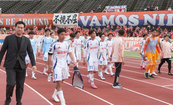 サポーターに挨拶して引き上げる新潟の選手。左は野澤洋輔社長＝４月１２日、高知市のＧＩＫＥＮスタジアム