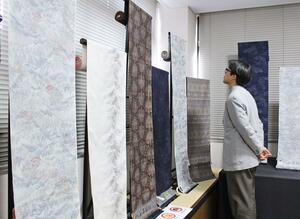 繊細な柄の小千谷紬が並ぶ展示＝小千谷市城内１