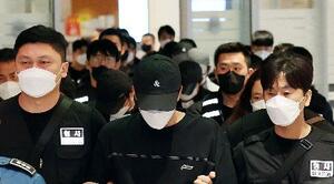 カンボジア拠点のフィッシング詐欺に関与した疑いなどで拘束され、韓国・仁川国際空港に到着した送還者(中央)ら=18日(聯合=共同)