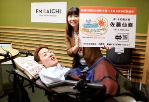 FM番組「寝たきり社長のおはようエール」のパーソナリティーを務める佐藤仙務さん(手前)=5月、名古屋市