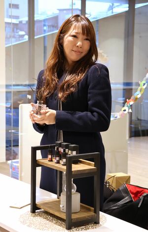 試作品を前に、クロモジの枝を手にする志水八千代さん=十日町市本町1