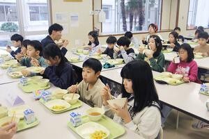 児童と生産者が有機米のご飯を味わった交流給食会=阿賀野市保田