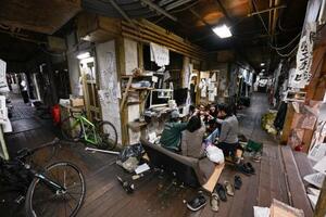 受付前のコタツで乾杯する京都大・吉田寮の寮生＝２０２６年２月、京都市左京区