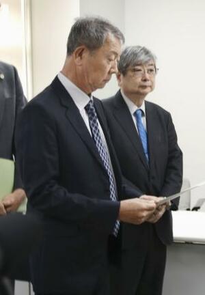 　東京都から調査報告書を受け取る江蔵智さん（手前）＝３月、都庁