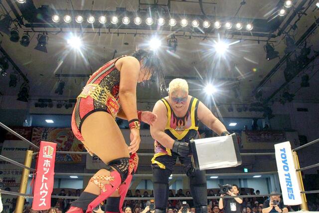 アジャコング選手（右）から攻められる里村明衣子選手＝４月２９日、東京・後楽園ホール