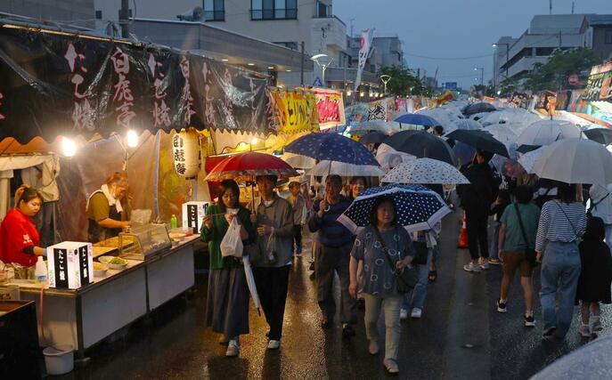 激しく雨が降る中、大勢の来場者でにぎわったえんま市＝１４日、柏崎市