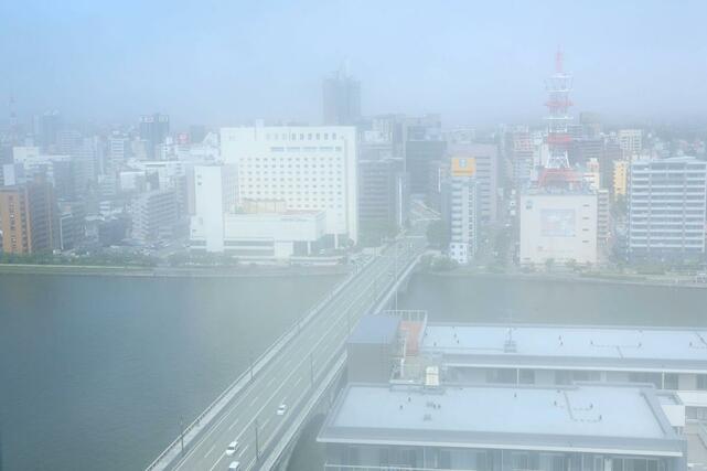 霧に包まれて見えなくなった古町エリアと萬代橋。中央奥はNEXT21=25日午前9時半過ぎ、新潟市中央区