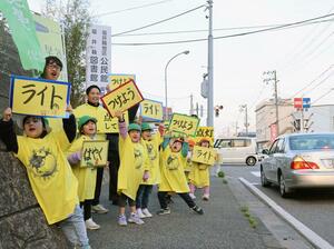 新大生と保育園児が早めのライト点灯を呼びかけた啓発活動=新潟市西区寺尾上2