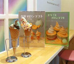 とりどりにトッピングされたソフトクリームと、夏季限定品のポップ。店内の壁には虹が描かれ、スイーツが映える=弥彦村矢作