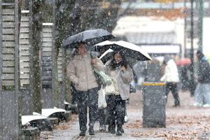 傘で雪をよけながら歩く市民ら=7日、新潟市中央区
