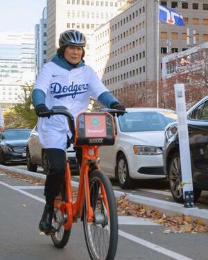 米大リーグ・ドジャースのユニホームを着て自転車に乗る、カナダ・トロントのオリビア・チャウ市長(市長のフェイスブックから、共同)