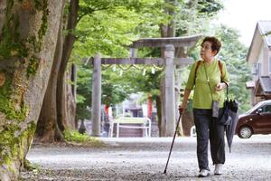 長岡空襲の夜、火の手を逃れようと走った金峯神社の参道を歩く遠藤良子さん=長岡市西蔵王2