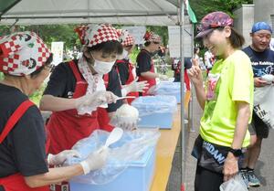 大盛りのご飯に笑顔を見せる南魚沼グルメマラソンの参加者=南魚沼市浦佐