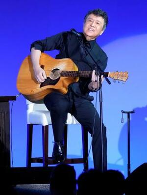 自民党大会に特別ゲストとして登場し、弾き語りする音楽家の世良公則さん=12日午前、東京都内