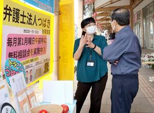 六・十朝市に出店し、買い物客の相談に応じる井之上彩弁護士(左)=7月31日、妙高市朝日町1
