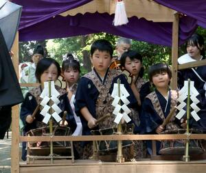 屋台の中で太鼓と鼓を元気よく打ち鳴らす児童=13日、佐渡市新穂潟上