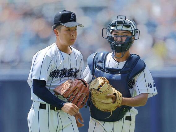 中越－新潟産大付　８回裏無死三塁のピンチを無失点で切り抜け、グラブを合わせる新潟産大付のエース小平乃希（左）と捕手角張奏真＝エコスタ