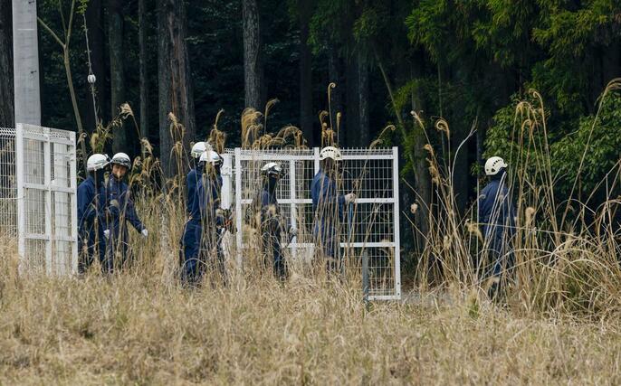 前日にスニーカーが発見された山中付近の捜索に向かう京都府警の捜査員＝１３日午後０時５９分、京都府南丹市